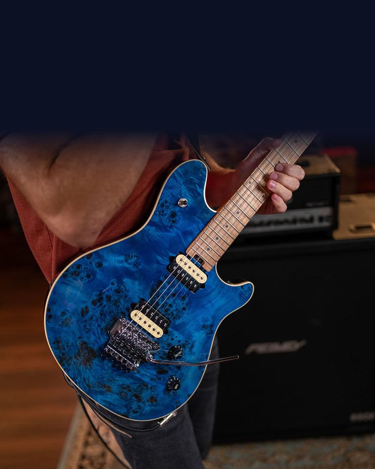 Musician playing Peavey HP2 blue burl guitar near Peavey amp